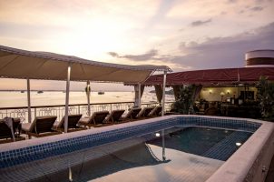 Swimming pool on deck of boutique river cruise ship The Jahan (Heritage Line) on Mekong river at sunset, Cai Lậy, Tiền Giang, Vietnam
