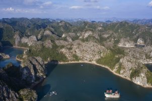 Aerial of boutique cruise ship Ylang (Heritage Line) with raised sails, Lan Ha Bay, Haiphong, Vietnam